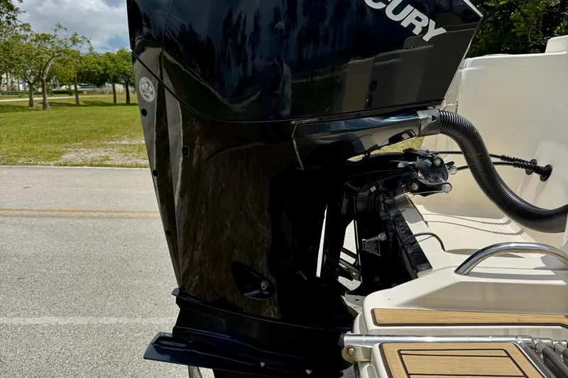 Slide: The Image of 2023 Scout 215 Dorado boat with Mercury outboard motor, parked on a sunny day. - 31
