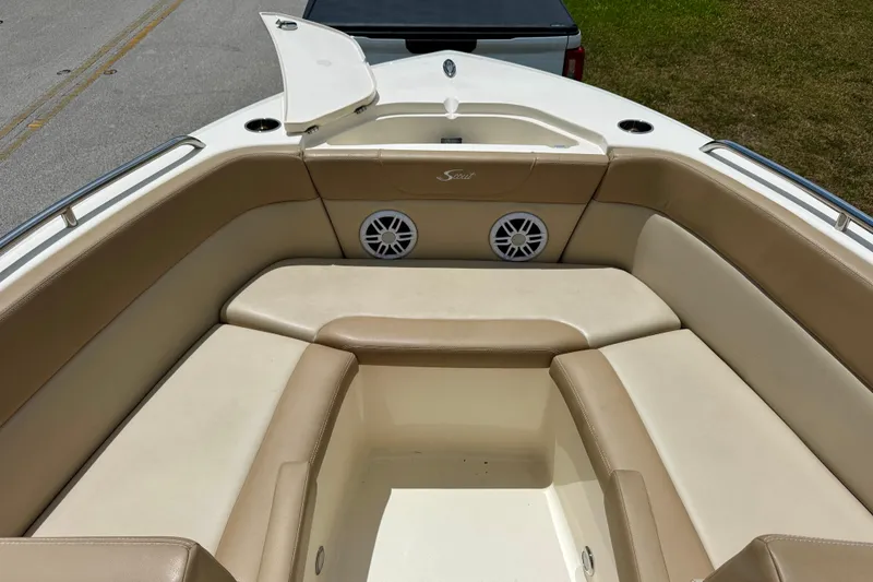 Slide: The Image of 2023 Scout 215 Dorado boat interior with beige seating and storage compartment. - 8