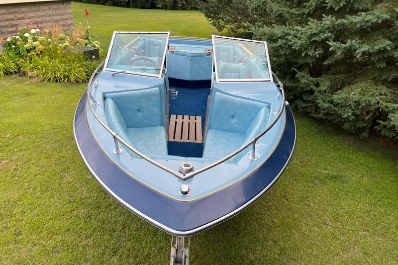 Slide: The Image of 1983 Century 3000 Bowrider boat with blue interior, parked on grass. - 20