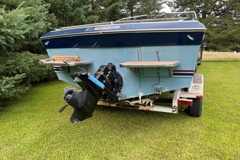 Slide: The Image of 1983 Century 3000 Bowrider boat on trailer, parked on grass, rear view. - 4