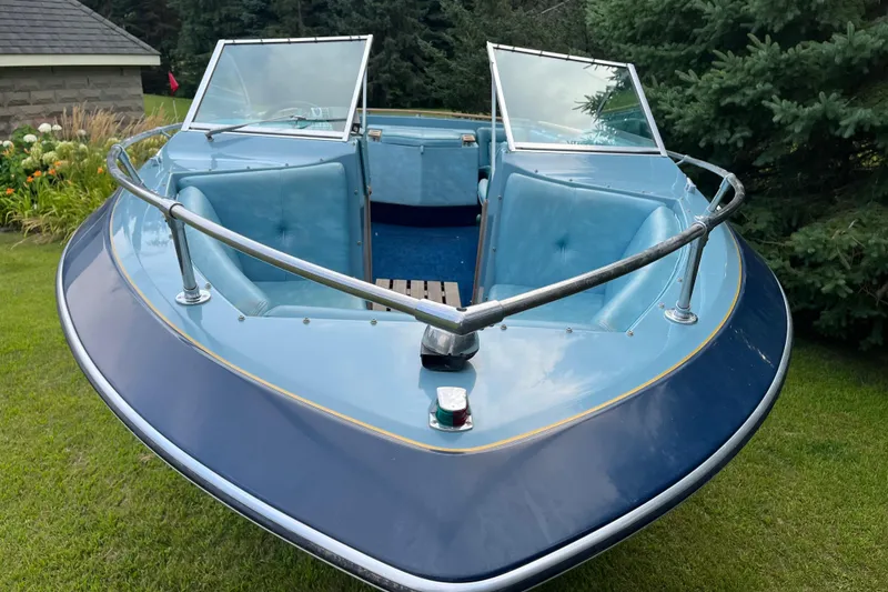Slide: The Image of 1983 Century 3000 Bowrider boat with blue interior, parked on grass. - 6