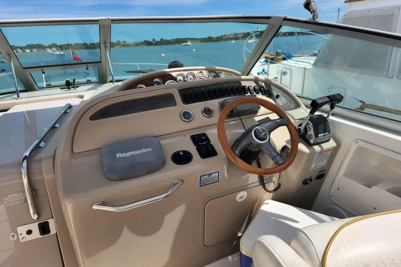 Slide: The Image of 1999 Sea Ray 310 Sundancer helm with steering wheel and navigation equipment. - 10