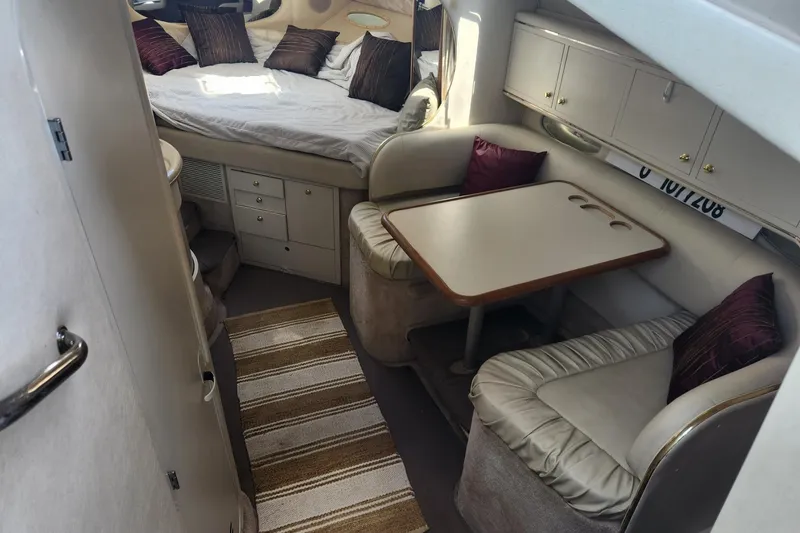 Slide: The Image of Interior of 1999 Sea Ray 310 Sundancer with cozy seating and sleeping area. - 14
