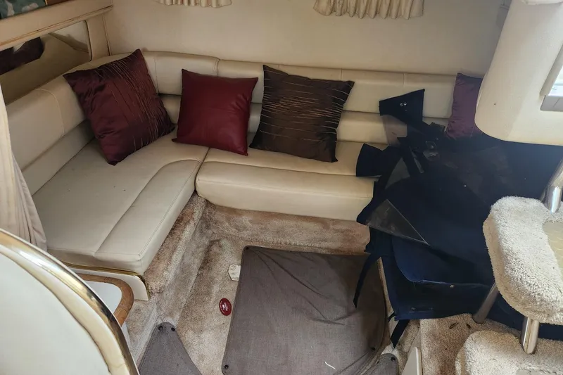 Slide: The Image of Interior of 1999 Sea Ray 310 Sundancer with beige seating and decorative pillows. - 17