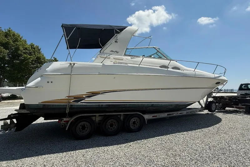 Slide: The Image of 1999 Sea Ray 310 Sundancer boat on trailer under clear blue sky. - 22