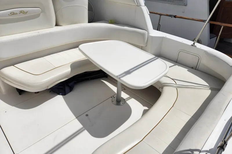 Slide: The Image of 1999 Sea Ray 310 Sundancer boat interior with white seating and table. - 6