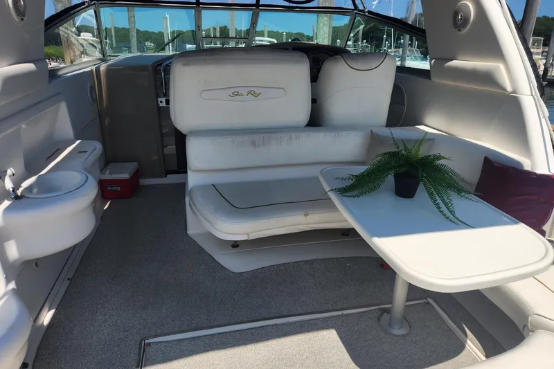 Slide: The Image of 1999 Sea Ray 310 Sundancer interior with seating, table, and potted plant. - 7