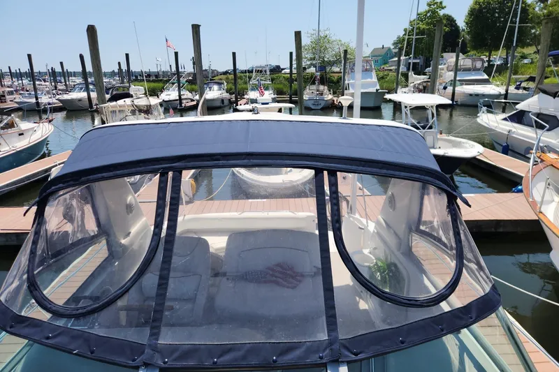 Slide: The Image of 1999 Sea Ray 310 Sundancer docked at a marina, featuring a covered cockpit. - 8
