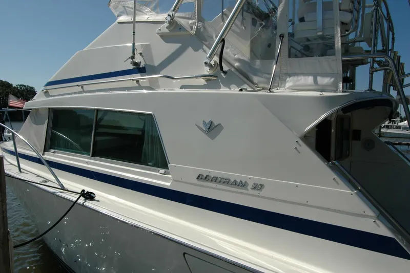 Slide: The Image of 1987 Bertram 33 Sport Fisherman boat docked, showcasing sleek design and classic style. - 10