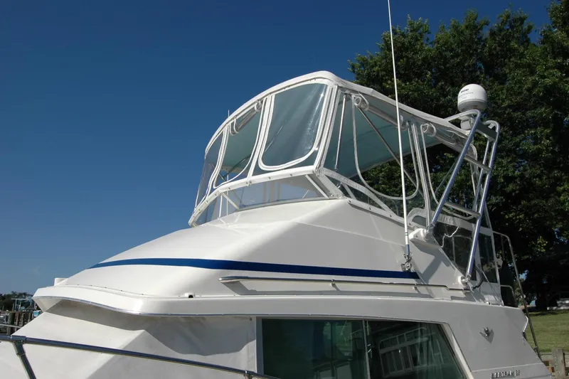 Slide: The Image of 1987 Bertram 33 Sport Fisherman boat with blue accents under clear sky. - 13
