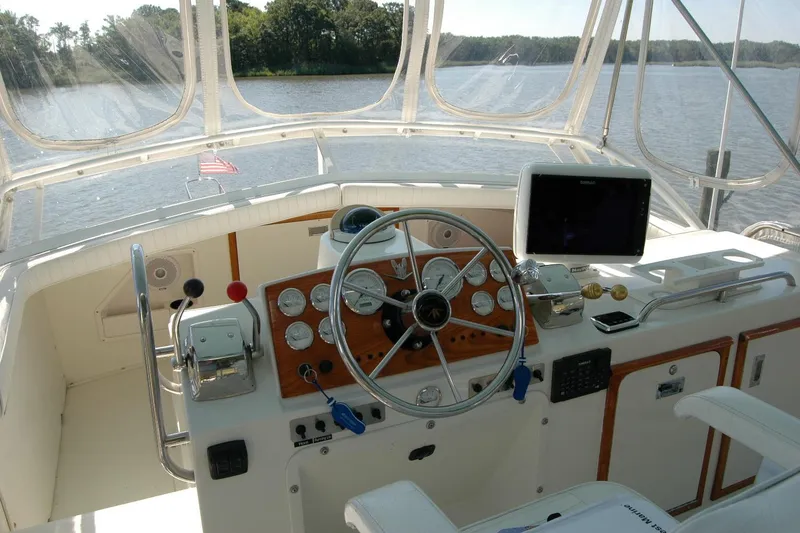 Slide: The Image of 1987 Bertram 33 Sport Fisherman helm with steering wheel, gauges, and navigation equipment. - 30