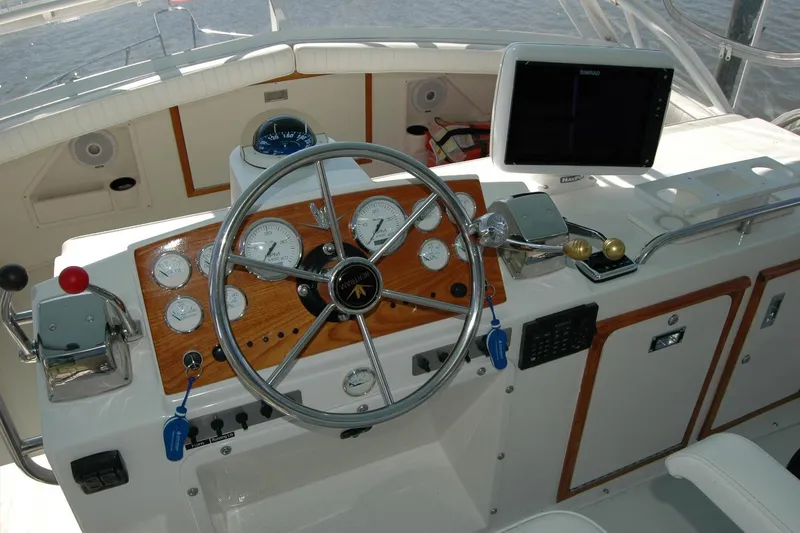 Slide: The Image of 1987 Bertram 33 Sport Fisherman helm with steering wheel, gauges, and navigation equipment. - 33