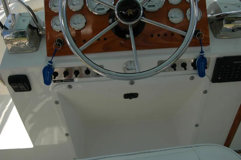 Slide: The Image of 1987 Bertram 33 Sport Fisherman helm with gauges, steering wheel, and control panel. - 35