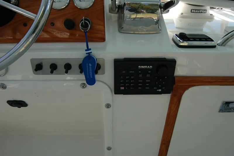 Slide: The Image of Control panel of a 1987 Bertram 33 Sport Fisherman with Simrad electronics and steering wheel. - 36