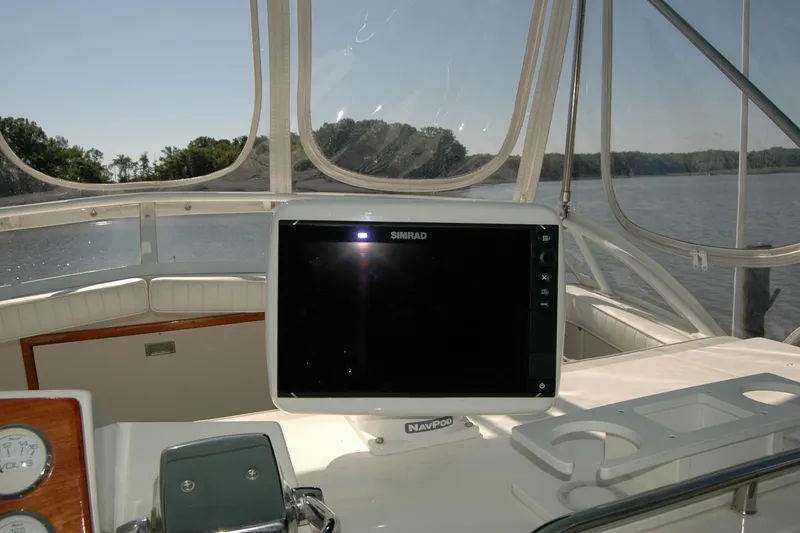 Slide: The Image of 1987 Bertram 33 Sport Fisherman helm with Simrad navigation system, overlooking calm waters. - 37