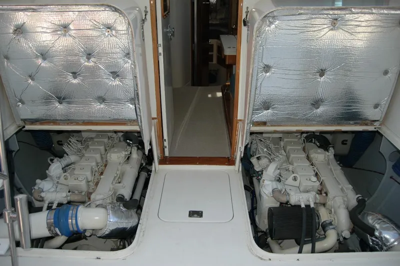 Slide: The Image of Engine compartment of 1987 Bertram 33 Sport Fisherman with dual engines and insulated covers. - 44