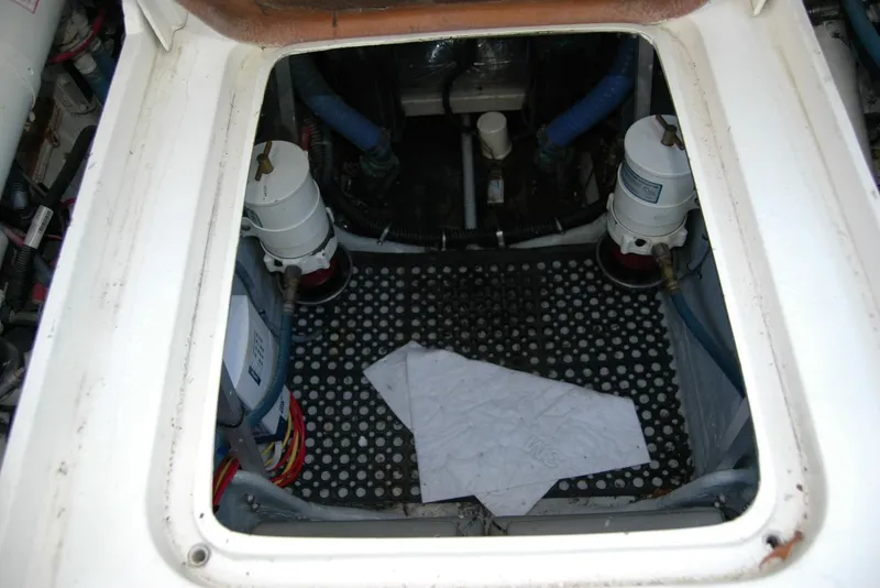 Slide: The Image of Engine compartment of a 1987 Bertram 33 Sport Fisherman boat, showing filters and hoses. - 52