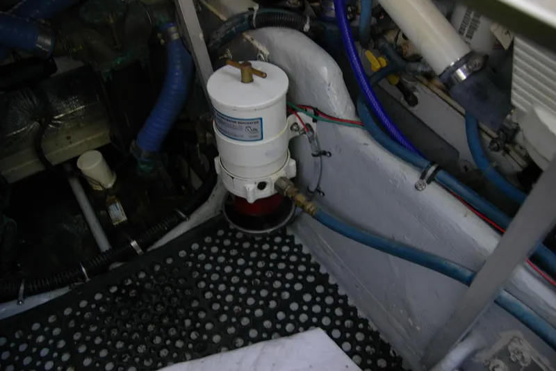 Slide: The Image of Engine compartment of 1987 Bertram 33 Sport Fisherman with visible fuel filter and hoses. - 54