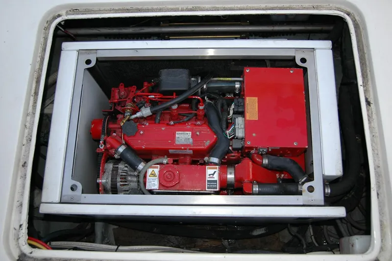 Slide: The Image of Engine compartment of a 1987 Bertram 33 Sport Fisherman boat, featuring a red engine. - 56