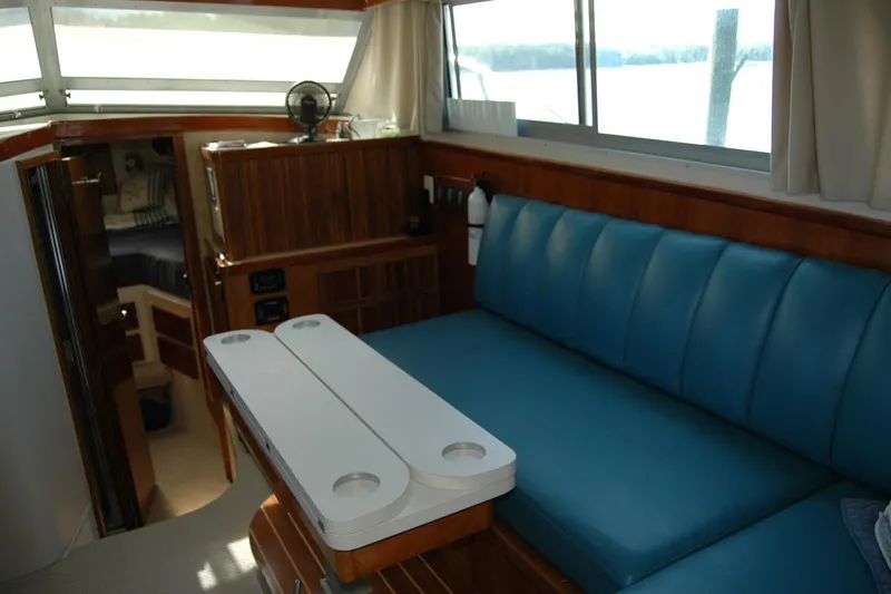 Slide: The Image of Interior of 1987 Bertram 33 Sport Fisherman with blue seating and wooden accents. - 63