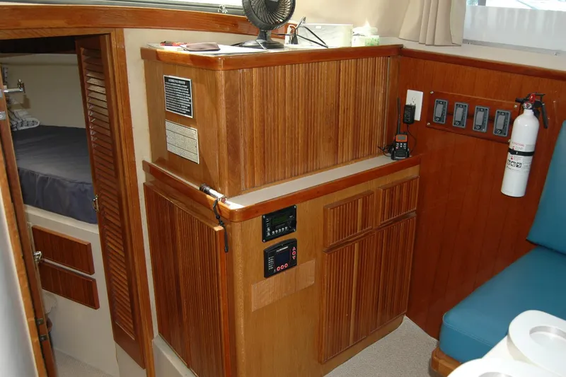 Slide: The Image of 1987 Bertram 33 Sport Fisherman interior with wood cabinetry and safety equipment. - 64