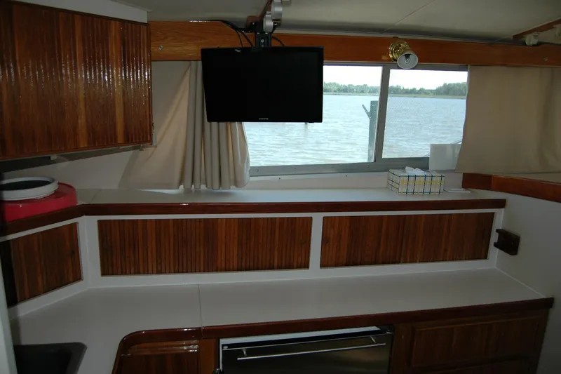 Slide: The Image of Interior of 1987 Bertram 33 Sport Fisherman with wood cabinets and window view. - 70