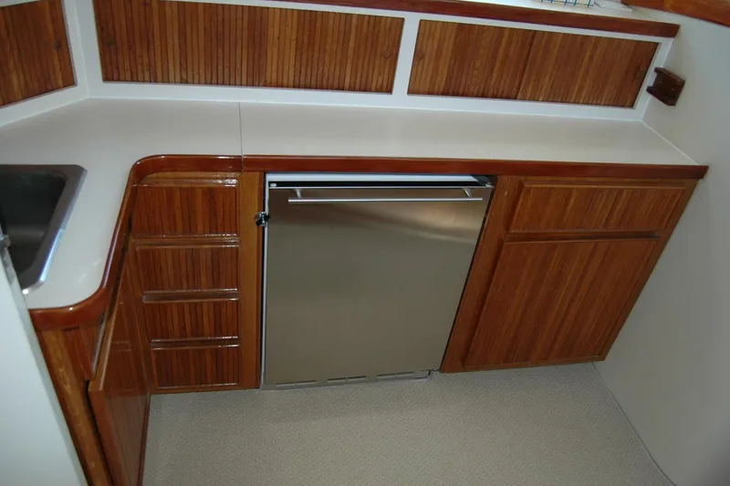 Slide: The Image of 1987 Bertram 33 Sport Fisherman galley with wood cabinetry and stainless steel appliances. - 71