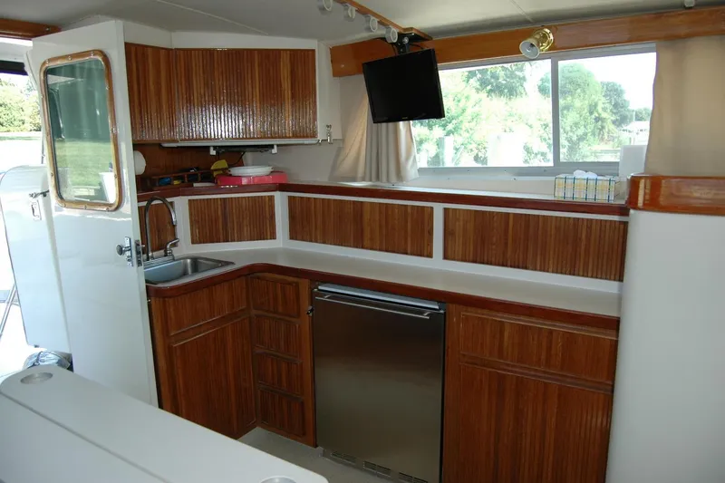 Slide: The Image of 1987 Bertram 33 Sport Fisherman interior with wood cabinetry and stainless steel appliances. - 73