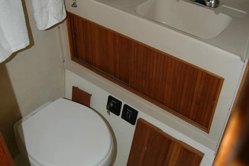Slide: The Image of 1987 Bertram 33 Sport Fisherman bathroom with wooden cabinetry and compact sink. - 79
