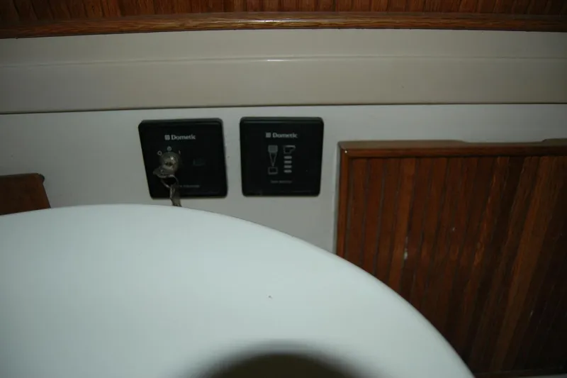 Slide: The Image of 1987 Bertram 33 Sport Fisherman interior with Dometic control panels and wooden cabinetry. - 81