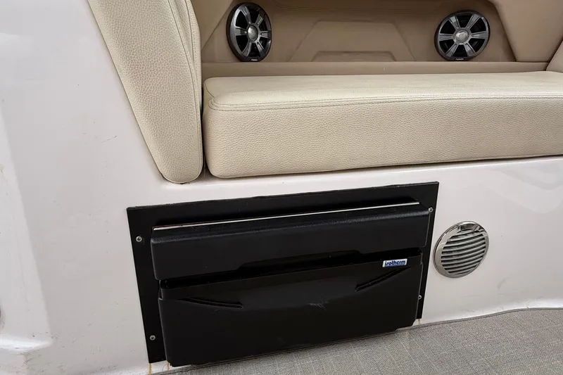 Slide: The Image of 2020 Regal 28 Express boat interior with beige seating and built-in speakers. - 14