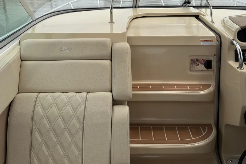Slide: The Image of 2020 Regal 28 Express boat interior with beige seating and wooden steps. - 15
