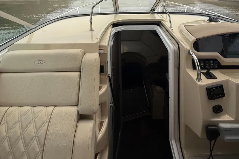 Slide: The Image of 2020 Regal 28 Express boat interior with beige seating and cabin entrance. - 16