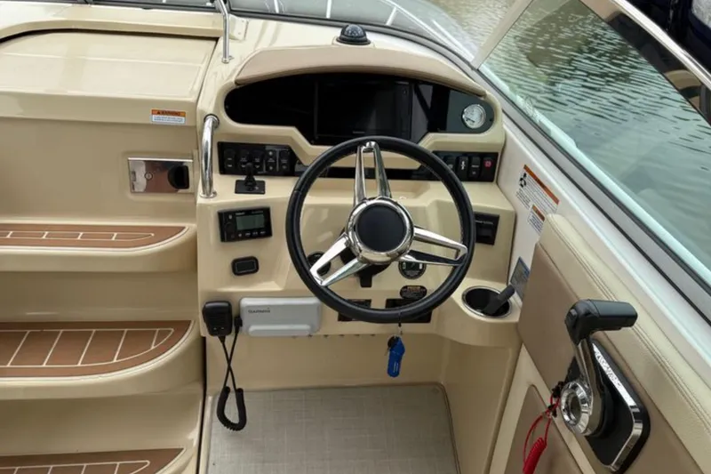 Slide: The Image of 2020 Regal 28 Express boat helm with steering wheel and control panel. - 17