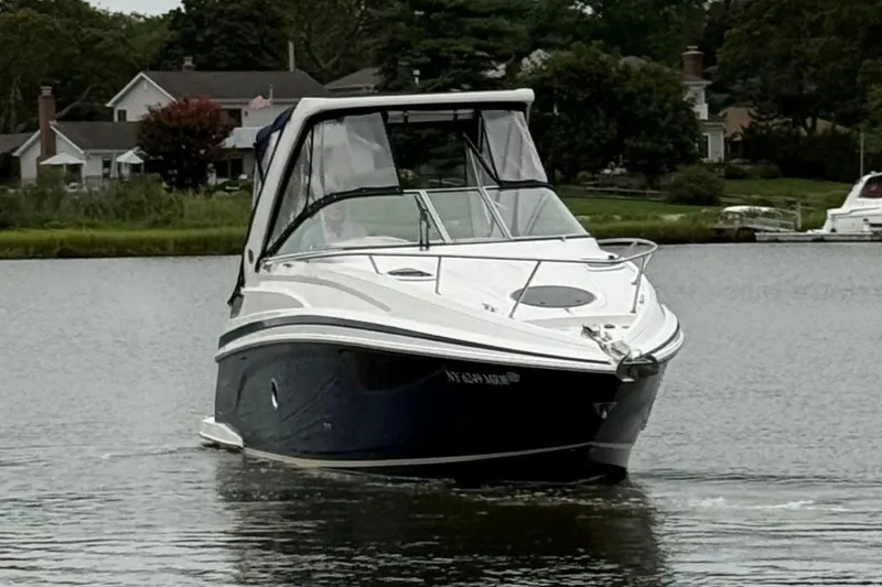 Slide: The Image of 2020 Regal 28 Express boat cruising on a calm lake near residential area. - 2