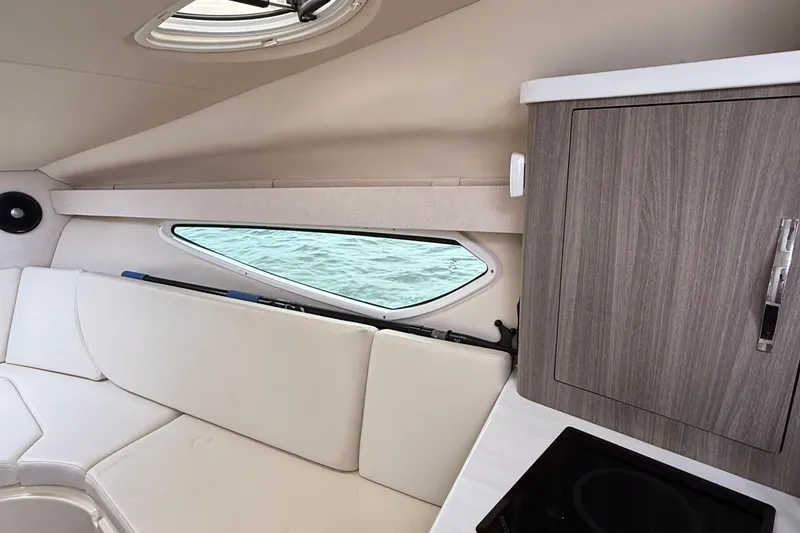 Slide: The Image of Interior of 2020 Regal 28 Express boat with white seating and wooden cabinetry. - 26