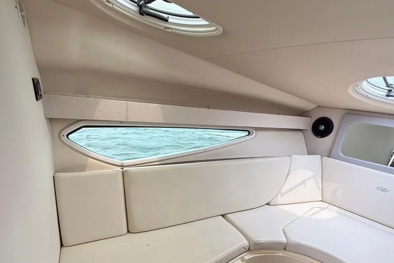 Slide: The Image of 2020 Regal 28 Express cabin interior with beige seating and water view. - 27