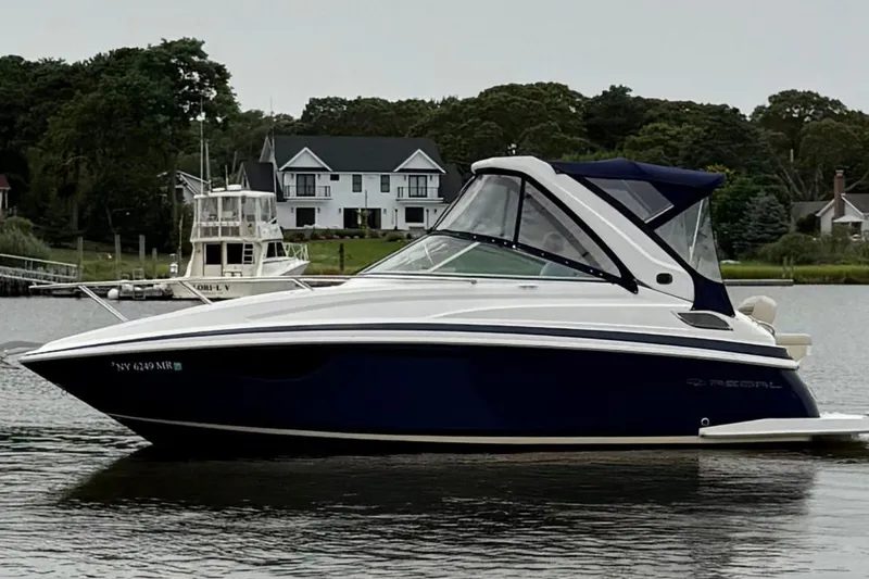 Slide: The Image of 2020 Regal 28 Express boat on calm water near residential area. - 3