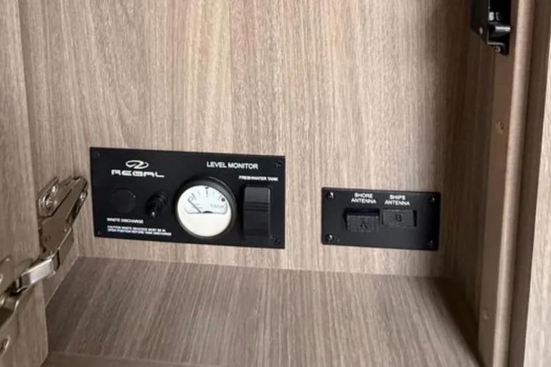 Slide: The Image of Control panel inside 2020 Regal 28 Express boat, featuring level monitor and antenna switches. - 30