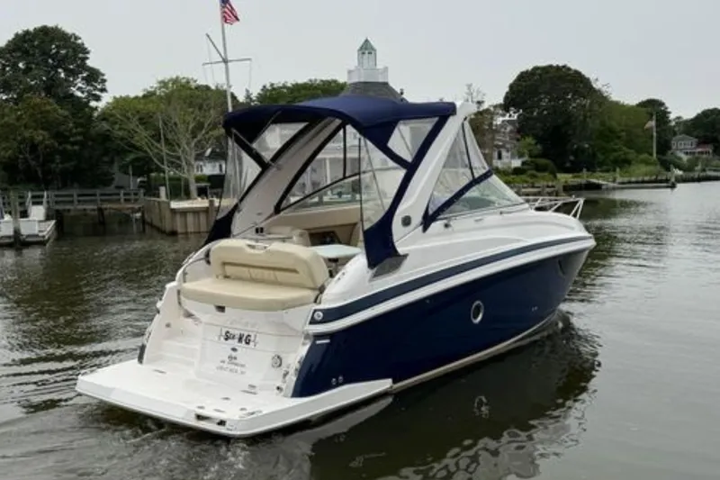 Slide: The Image of 2020 Regal 28 Express boat cruising on a calm river with lush greenery. - 7