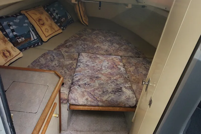 Slide: The Image of 1996 Bayliner 2252 Ciera Express cabin interior with patterned cushions and nautical-themed pillows. - 30