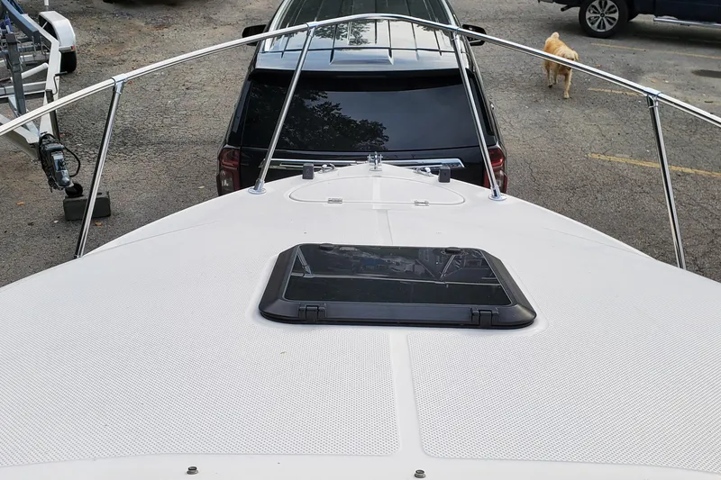Slide: The Image of 1996 Bayliner 2252 Ciera Express boat deck with hatch, parked near vehicles. - 34