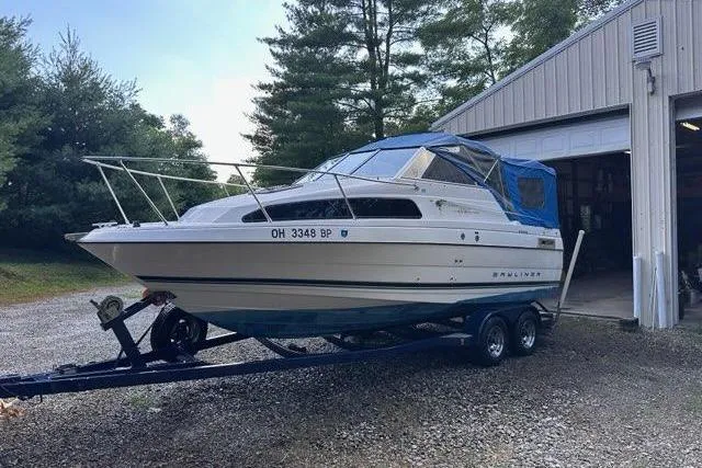 Slide: The Image of 1996 Bayliner 2252 Ciera Express boat on trailer near garage, surrounded by trees. - 38