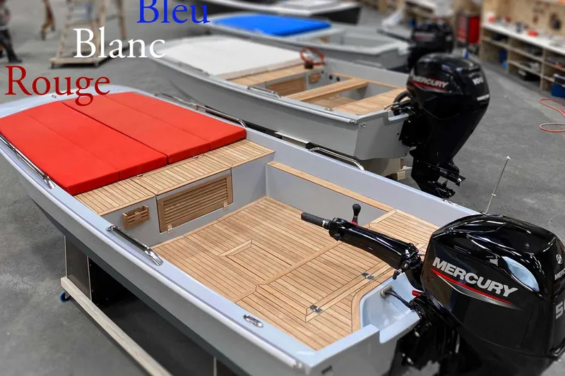 Slide: The Image of Two Black Pepper Tender 17 boats with Mercury engines, featuring red cushions and wooden decks. - 9