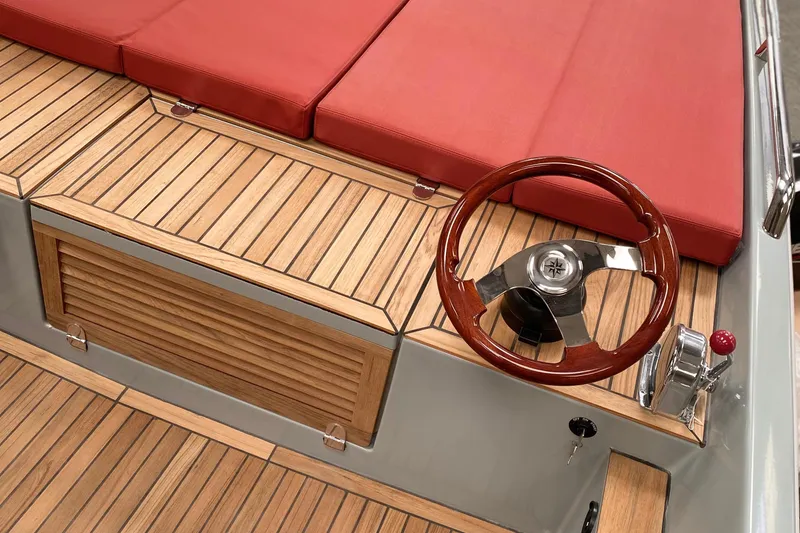 Slide: The Image of Luxurious Black Pepper Tender 17 boat interior with red cushions and wooden steering wheel, 2026 model. - 7