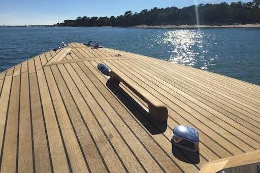 Slide: The Image of 2026 Black Pepper Tender 24 boat deck on sunny water, wooden finish. - 20