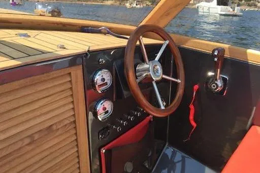 Slide: The Image of 2026 Black Pepper Tender 24 boat interior with wooden steering wheel and control panel. - 22