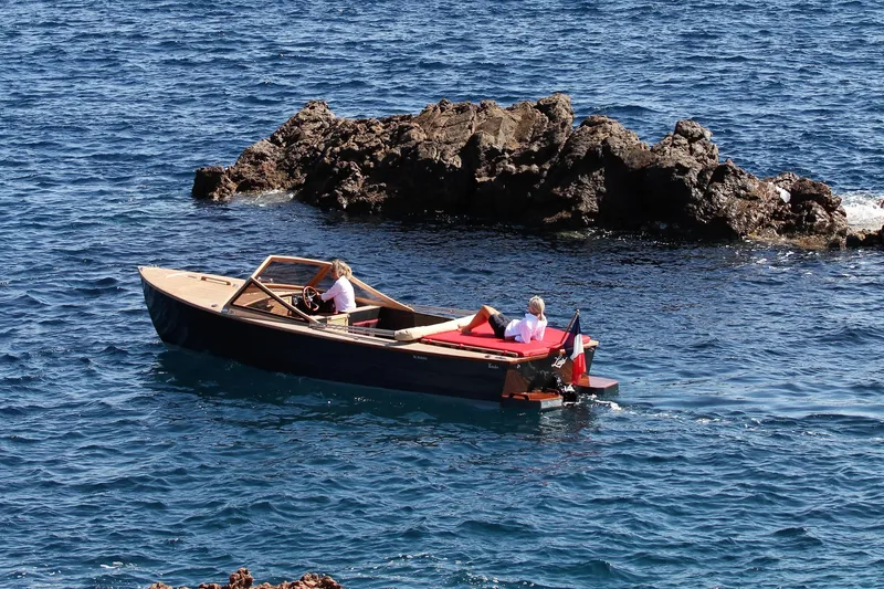 Slide: The Image of Black Pepper Tender 24 boat cruising near rocky coastline, 2026 model. - 16