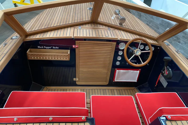 Slide: The Image of Interior of 2026 Black Pepper Tender 24 yacht with wooden finish and red cushions. - 12