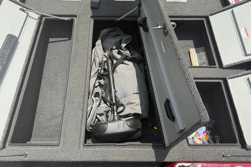 Slide: The Image of Open storage compartment on 2021 SeaArk BC 210 boat with gear inside. - 14